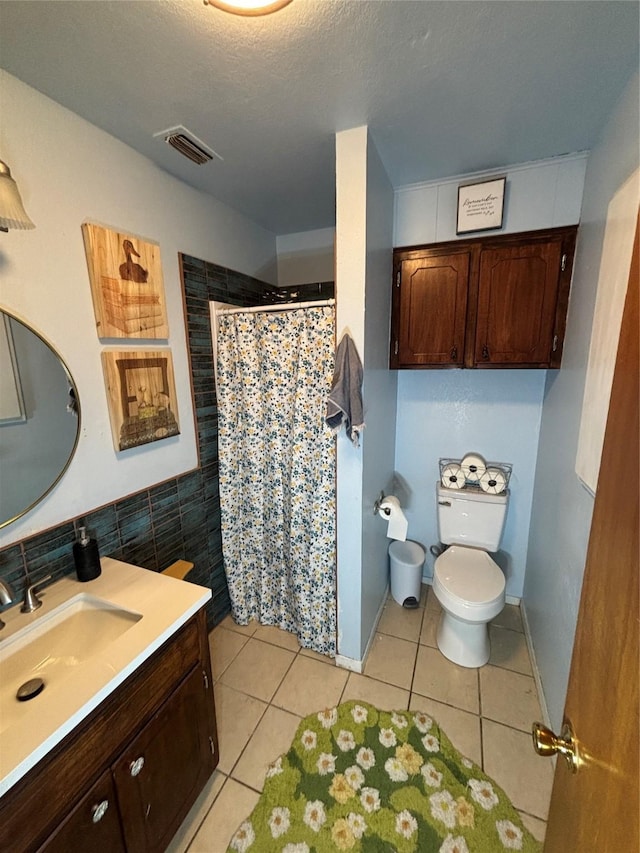 1207 W Cage St, Stephenville, TX 76401 - bathroom with visible vents, tile walls, tile patterned flooring, curtained shower, and toilet