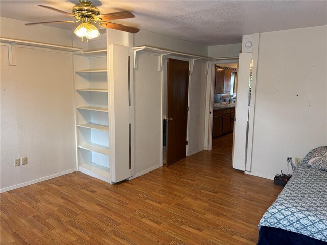 1207 W Cage St, Stephenville, TX 76401 - bedroom with baseboards, a textured ceiling, ceiling fan, and wood finished floors