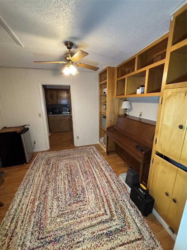 1207 W Cage St, Stephenville, TX 76401 - interior space with baseboards, ceiling fan, a textured ceiling, and wood finished floors