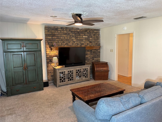 1207 W Cage St, Stephenville, TX 76401 - carpeted living area featuring a textured ceiling, ceiling fan, visible vents, and wood walls