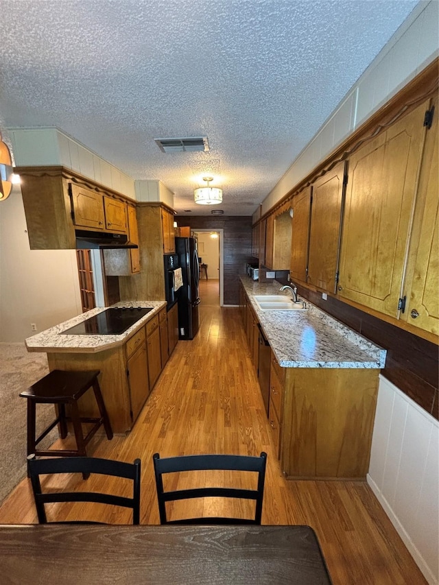 1207 W Cage St, Stephenville, TX 76401 - kitchen featuring visible vents, light wood finished floors, a sink, and black appliances