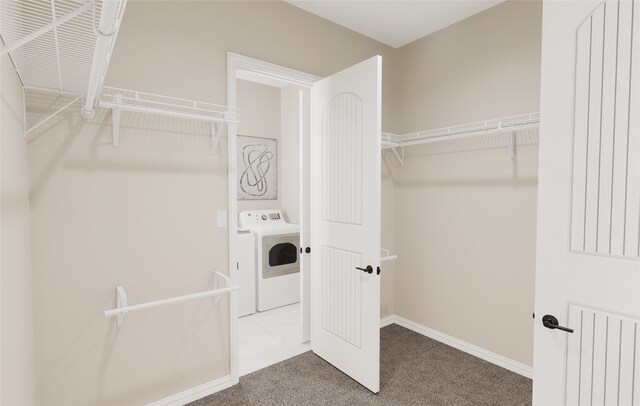 clothes washing area featuring laundry area, washer / dryer, baseboards, and carpet