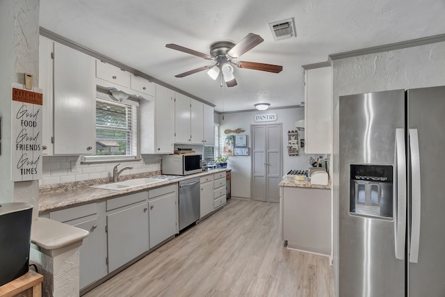 kitchen with visible vents, ceiling fan, tasteful backsplash, a sink, and appliances with stainless steel finishes