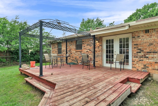 deck with french doors, fence, outdoor dining area, and a lawn