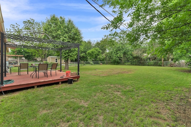 view of yard with a storage unit, a fenced backyard, a wooden deck, and an outdoor structure