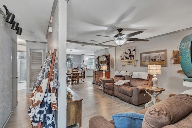 living area with ceiling fan, wood finished floors, and visible vents