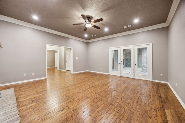 empty room featuring french doors, a ceiling fan, visible vents, wood finished floors, and ornamental molding