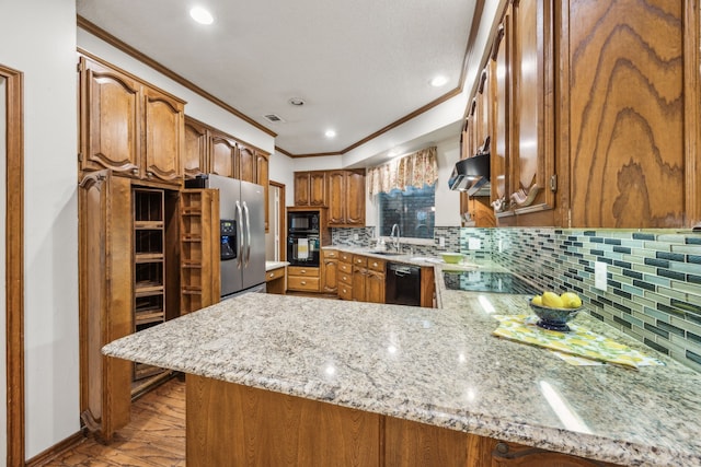 kitchen featuring brown cabinets, a sink, black appliances, a peninsula, and ornamental molding