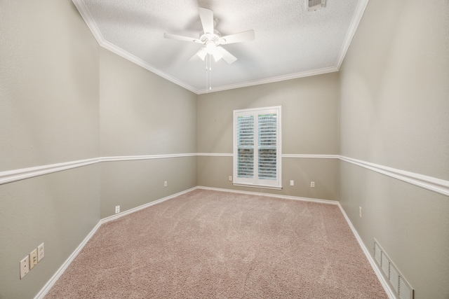 spare room with ornamental molding, carpet, a ceiling fan, and visible vents