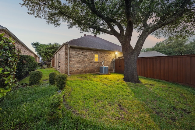 view of yard featuring fence and central AC unit