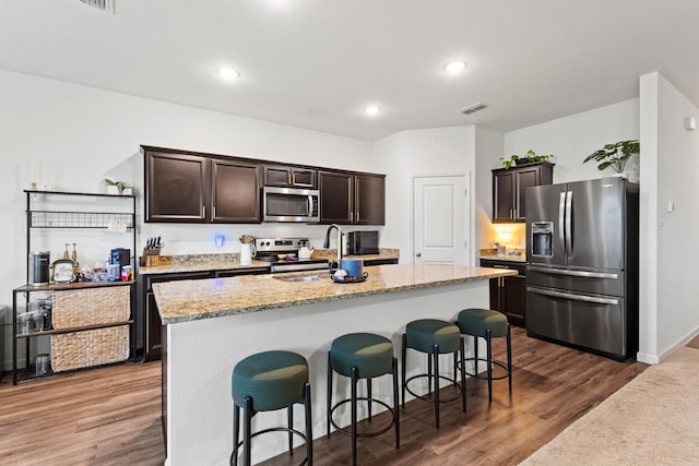 1823 Wolf Run, Anna, TX 75409 - kitchen featuring visible vents, a kitchen island with sink, a breakfast bar, a sink, and appliances with stainless steel finishes