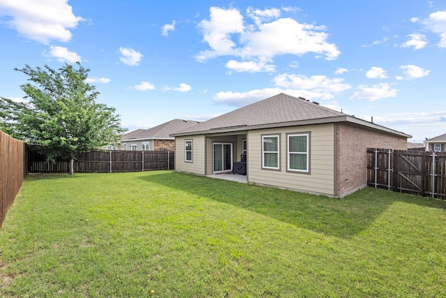 1823 Wolf Run, Anna, TX 75409 - back of house featuring a lawn, a fenced backyard, brick siding, and a patio