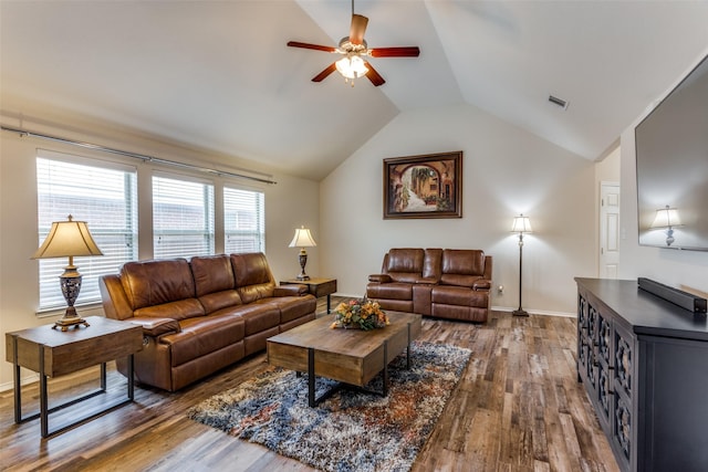 living area featuring dark wood-type flooring, baseboards, ceiling fan, and vaulted ceiling