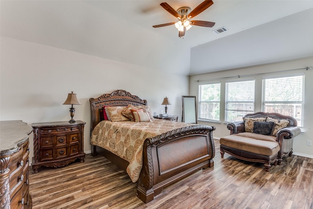 bedroom featuring a ceiling fan, baseboards, wood finished floors, lofted ceiling, and visible vents