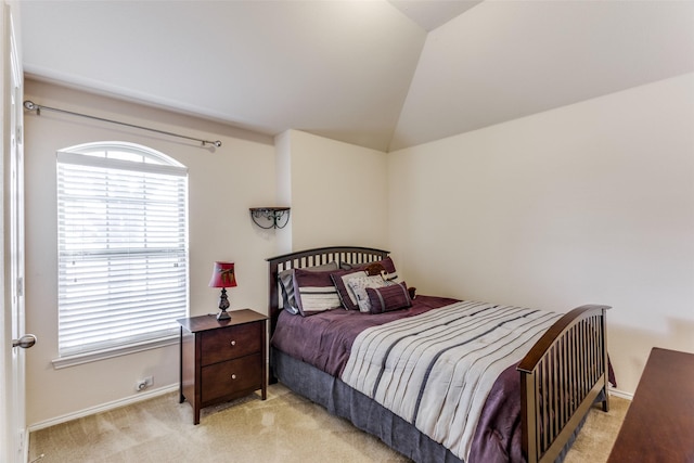 bedroom featuring baseboards, vaulted ceiling, and light colored carpet
