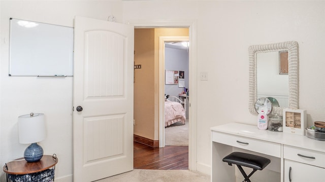 corridor featuring baseboards and wood finished floors