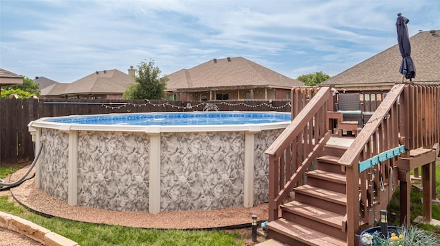 view of pool with a fenced in pool, stairs, a fenced backyard, and a deck