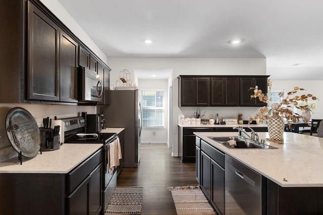 3033 Zinnia St, Royse City, TX 75189 - kitchen featuring stainless steel appliances, a sink, dark wood-type flooring, dark brown cabinetry, and an island with sink
