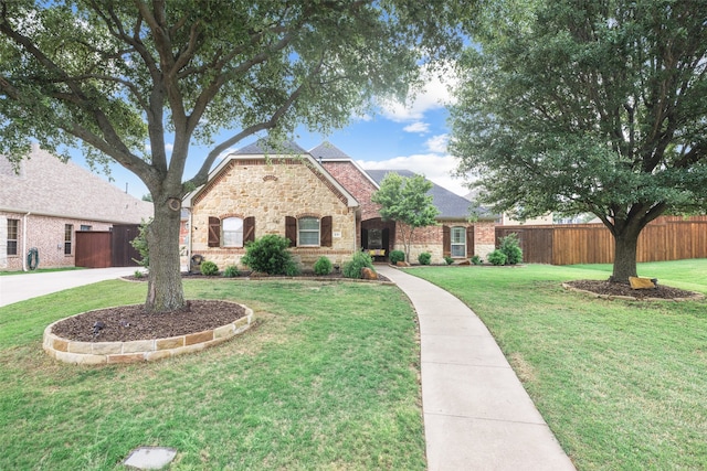 view of front of property with fence, a front lawn, and stone siding