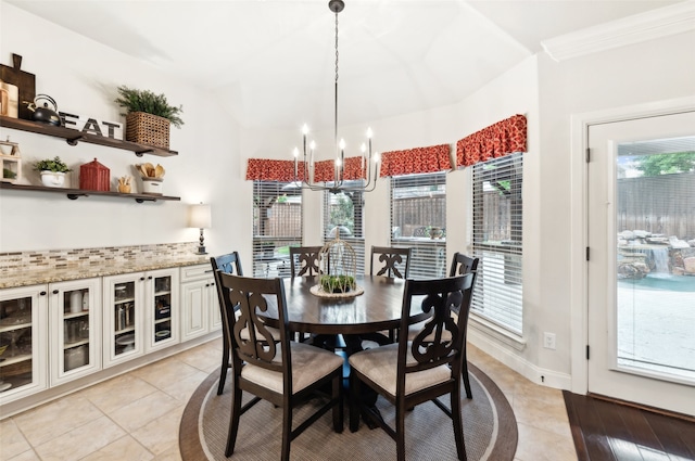 dining space with an inviting chandelier, baseboards, plenty of natural light, and light tile patterned floors