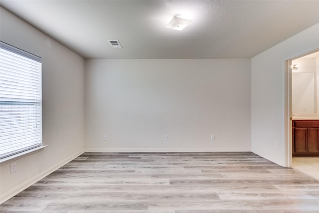 unfurnished room with visible vents and light wood finished floors