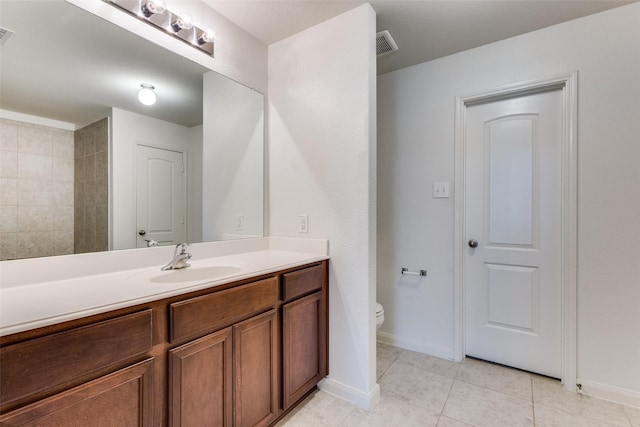 bathroom featuring vanity, visible vents, toilet, baseboards, and tile patterned floors