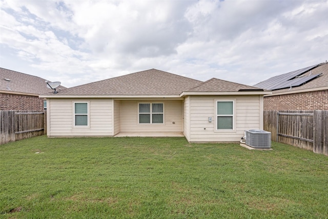 back of house featuring a lawn, a fenced backyard, and cooling unit