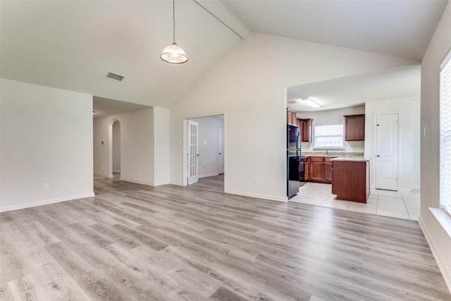 unfurnished living room with visible vents, beamed ceiling, high vaulted ceiling, arched walkways, and light wood-style flooring