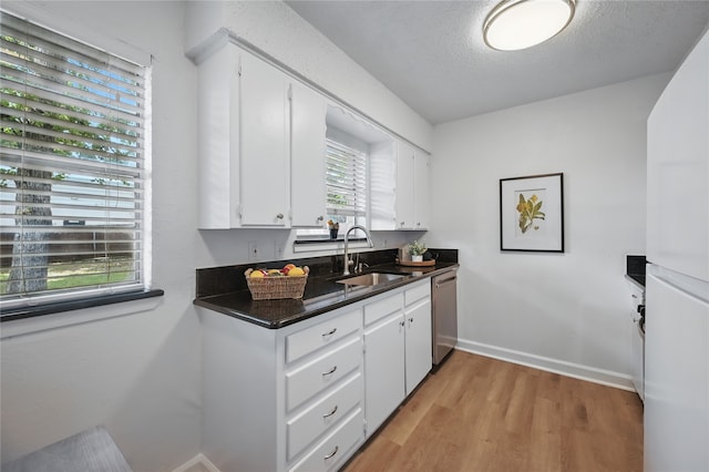 528 Chambers St, Denton, TX 76205 - kitchen with dark countertops, light wood-type flooring, dishwasher, a sink, and white cabinetry