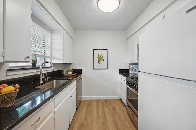 528 Chambers St, Denton, TX 76205 - kitchen with a sink, light wood-style flooring, appliances with stainless steel finishes, and white cabinets