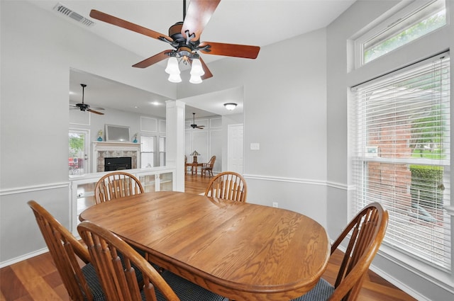 818 Red Oak Dr, Mansfield, TX 76063 - dining area featuring a ceiling fan, a tiled fireplace, baseboards, and wood finished floors