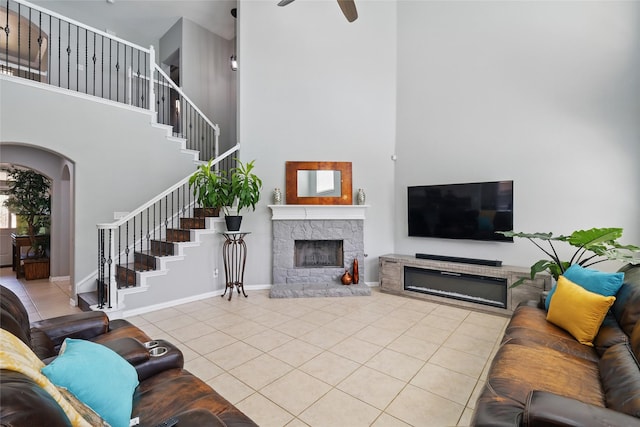8208 Rock Elm Rd, Fort Worth, TX 76131 - tiled living area with a high ceiling, a fireplace, stairs, a ceiling fan, and arched walkways