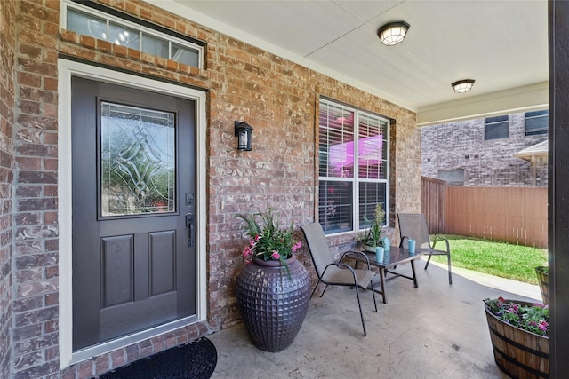 8208 Rock Elm Rd, Fort Worth, TX 76131 - view of exterior entry with a porch, brick siding, and fence
