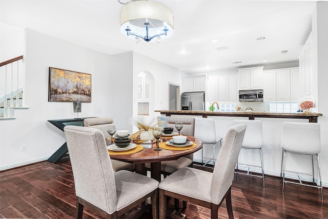 dining space featuring stairway, recessed lighting, dark wood-style flooring, and a chandelier