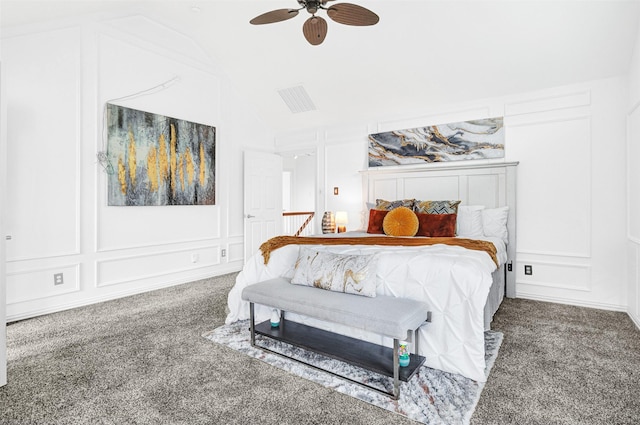 bedroom featuring carpet flooring, vaulted ceiling, and a decorative wall