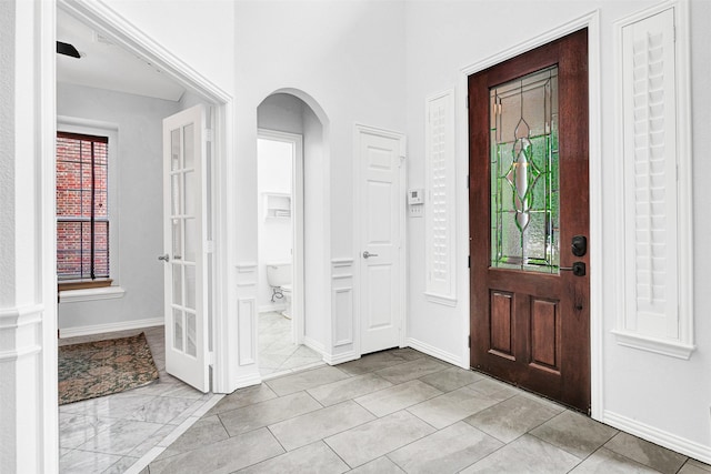 entrance foyer with arched walkways and baseboards