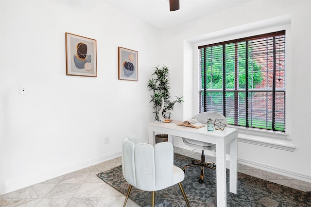 office area with ceiling fan and baseboards
