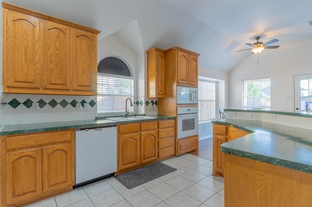 kitchen featuring dark countertops, white appliances, ceiling fan, a sink, and backsplash