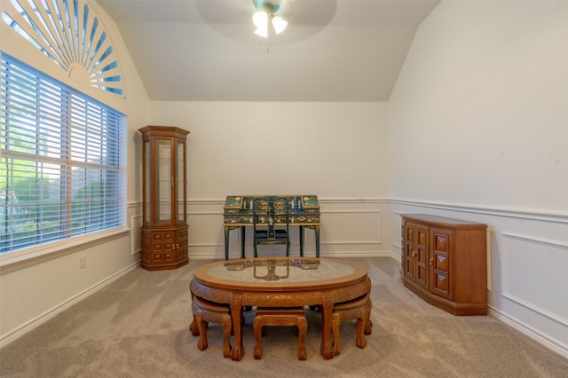 living area featuring carpet floors, ceiling fan, vaulted ceiling, and a wainscoted wall