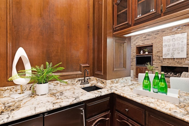bar featuring a sink, wet bar, a brick fireplace, and built in shelves