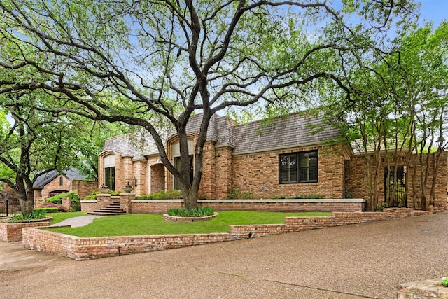 view of front of home featuring a front yard and brick siding