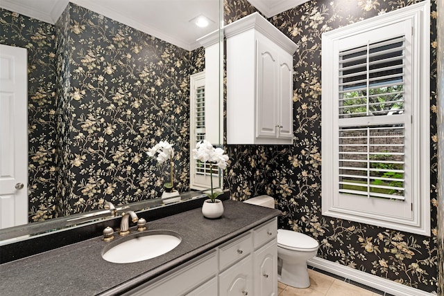bathroom featuring vanity, toilet, tile patterned floors, baseboards, and ornamental molding