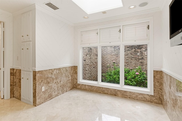 unfurnished room with a skylight, crown molding, recessed lighting, and visible vents