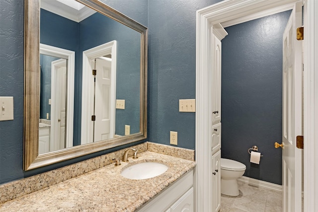 half bathroom with vanity, baseboards, crown molding, and toilet