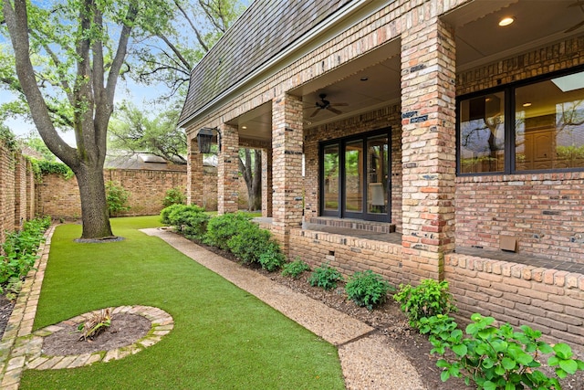 view of yard with french doors, fence, and a ceiling fan