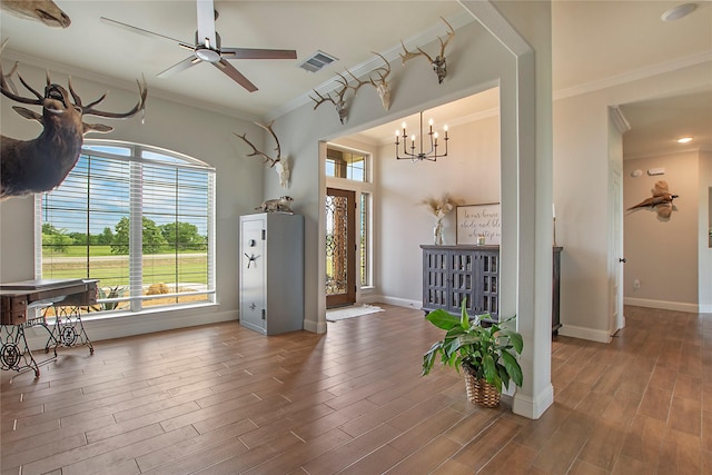 interior space featuring baseboards, ornamental molding, a healthy amount of sunlight, and wood finished floors