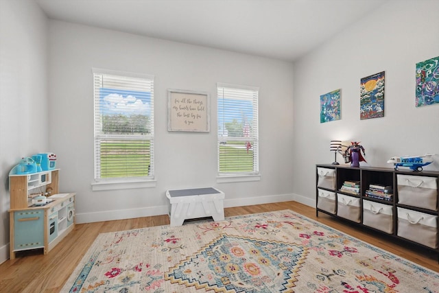 playroom featuring baseboards and wood finished floors