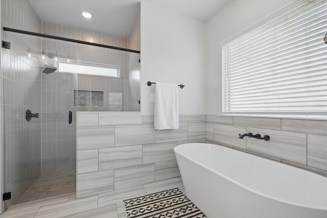 full bath with a freestanding tub, a shower stall, recessed lighting, and tile walls
