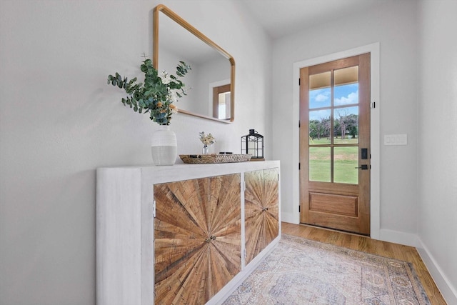 entryway featuring baseboards and wood finished floors