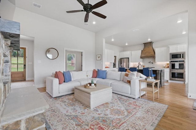 living area featuring ceiling fan, recessed lighting, baseboards, light wood-type flooring, and visible vents